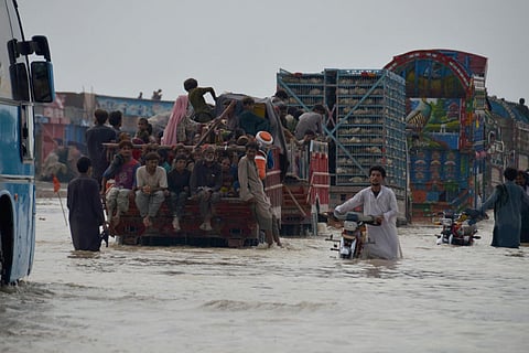 Displaced Pakistani families from flood hit areas board vehicles while they move to safe place, in Nasirabad, a district of Pakistan's southwestern Baluchistan province (Photo | AP)