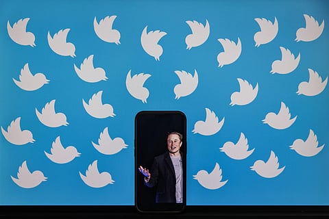 Illustration photo showing a cellphone displaying a photo of Elon Musk placed on a computer monitor filled with Twitter logos. (Photo | AFP)