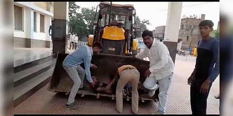 A man identified as Mahesh Barman had to be carried to the hospital by the JCB machine in the absence of ambulance. (Photo | Express)