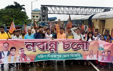 BJP supporters raise slogans before boarding a Kolkata-bound train to participate in the party's 'Nabanna Abhijan' march, to be held on Tuesday. (Photo | PTI)