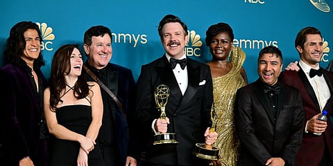 US actor Jason Sudeikis (C), surrounded by the cast and crew of 'Ted Lasso' poses with the Emmy for Outstanding Comedy Series during the 74th Emmy Awards.(Photo | AFP)