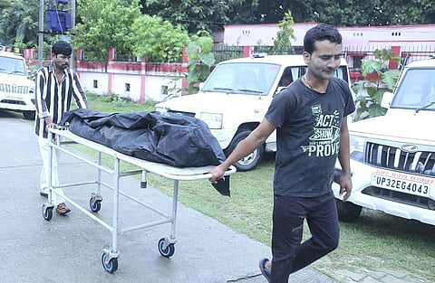 Mortal remains of one of two minor Dalit sisters allegedly raped and murdered being taken for post-mortem at a hospital, in Lakhimpur Kheri on Thursday. (Photo | PTI)