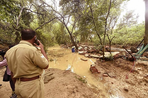 Debris lie on the ground after the boundary wall of an Army enclave collapsed due to heavy overnight rains, in Lucknow on Friday. (Photo | PTI)
