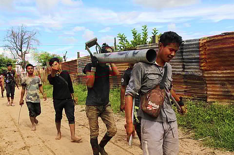 Anti-coup fighters walking with weapons in a township in Myanmar's northwestern Sagaing region.