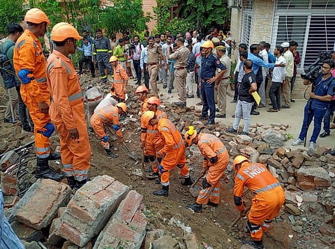 National Disaster Response Force (NDRF) personnel during a rescue operation after a portion of a boundary wall of a housing society collapsed, at Jal Vayu Vihar in Noida. (Photo | PTI)