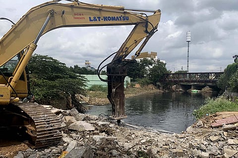 A bulldozer razes a compound wall on Sarjapur Road on Monday| Shashidhar Byrappa