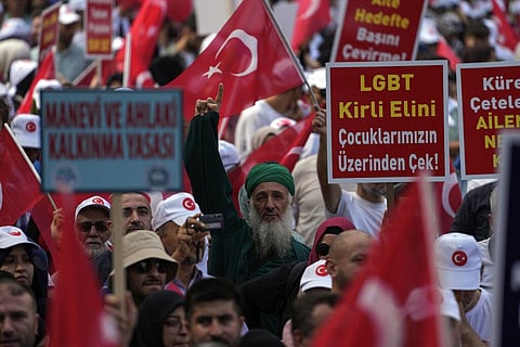 Demonstrators hold banners that read, 'Law for the development of the spirit and moral' and 'LGBTQ, remove your dirty hand from our children' during an anti LGBTQ protest (Photo | AP)