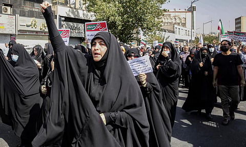 State television broadcast footage of pro-hijab demonstrators in central Tehran, many of them men but also women dressed in black chadors.(Photo | AFP)