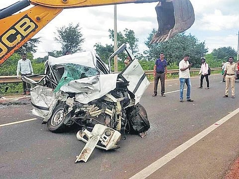 The damaged car being removed from the road by an earthmover, at Yaragatti Road in Saundatti taluk on Sunday | EXPRESS