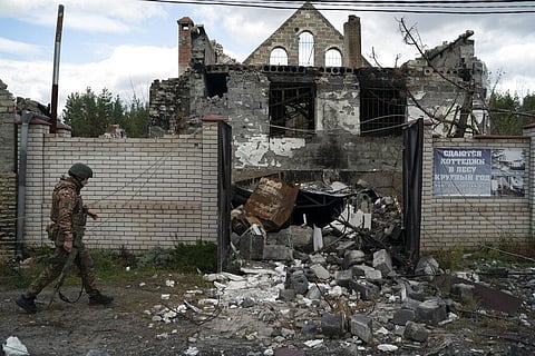 A Ukrainian serviceman from Dnipro-1 regiment walks past a damaged building in the retaken village of Shchurove, Ukraine, Sunday, Sept. 25, 2022. (Photo | AP)
