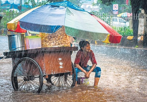 A gupchup vendor takes shelter from pounding rain, in Bhubaneswar on Monday | DEBADATTA MALLICK