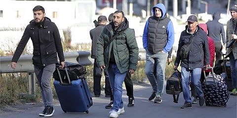 A group of Russians walk after crossing the border at Verkhny Lars between Georgia and Russia in Georgia. (Photo | AP)