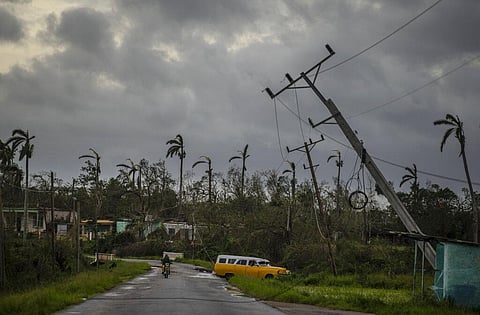 A classic American car drives past utility poles tilted by Hurricane Ian in Pinar del Rio, Cuba, Tuesday, Sept. 27, 2022 (Photo | AP)