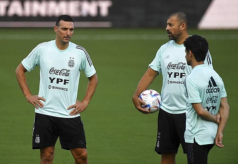 Argentina soccer coach Lionel Scaloni, left, talks to his staff as his players warm up during practice. (Photo | AP)