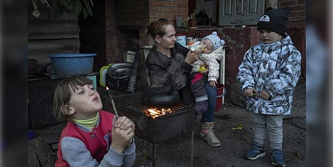 Margaryta Tkachenko feeds her 9-month-old daughter Sophia in the recently liberated town of Izium. (Photo | AP)