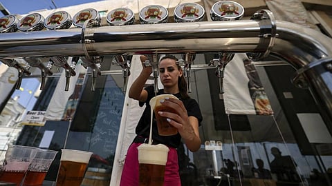 A bartender serves visitors at the annual beer festival in the Palestinian village of Taybeh in the Israeli-occupied West Bank. (Photo | AFP)