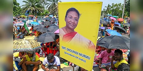 A member of Adivasi Sengel Abhiyan holds a poster of President Droupadi Murmu during a rally demanding recognition of the 'Sarna Dharam Code', in Kolkata. (Photo | PTI)