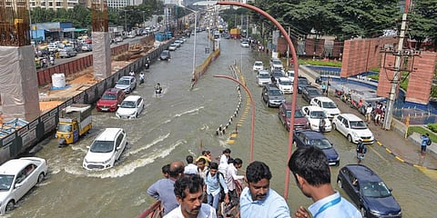 Vehicles pass through the waterlogged Outer Ring Road after heavy monsoon rains, near Bellandur in Bengaluru.(Photo | PTI)
