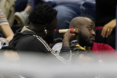 A fan gets a haircut as Nick Kyrgios, of Australia, plays Karen Khachanov, of Russia, during the quarterfinals of the U.S. Open tennis championships, Tuesday, Sept. 6, 2022, in New York. (Photo | AP)