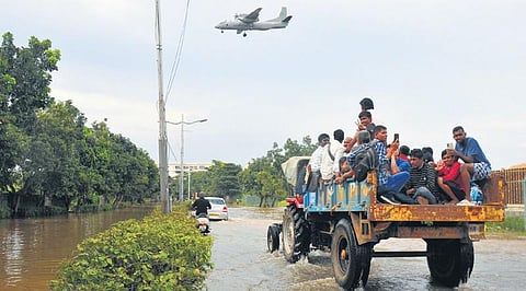 Desperate citizens ride a tractor on a flooded road in Mahadevapura, which has been rain-hit, in Bengaluru on Tuesday | Vinod Kumar T