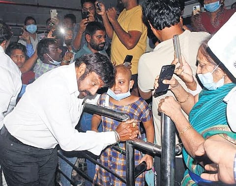 Actor and chairman of the Basavatarakam Indo-American Cancer Hospital Nandamuri Balakrishna, lends an ear to a young cancer patient as he arrives to inaugurate the new emergency ward at the hospital o