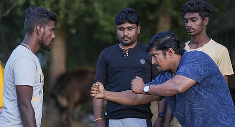 Jallikattu master trainer Mudakkathan Mani trains young men in taming bulls at Veerapandi village near Madurai. (Photo | PTI)