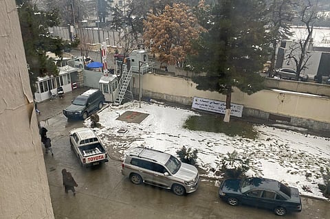 People walk past the parked vehicles after a suicide blast near Afghanistan's foreign ministry in Kabul on January 11, 2023.