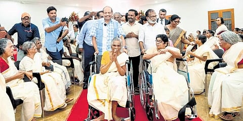 Yusuffali M A and Punalur Somarajan bring two wheelchair-bound inmates to the prayer hall of Gandhibhavan.