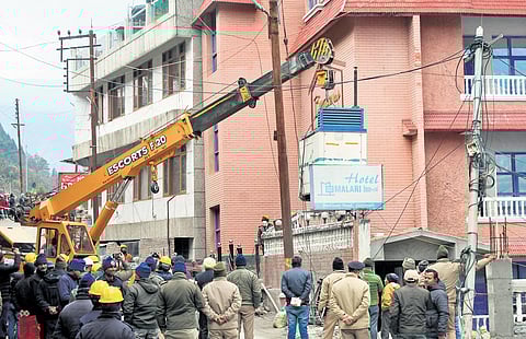 A crane takes out heavy equipment from the unsafe Hotel Malari Inn in Joshimath town as part of the demolition process that began on Thursday | PTI