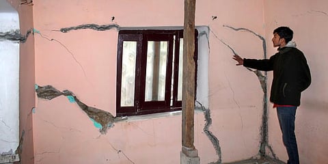 A resident shows cracks that appeared in a house, in Joshimath. (Photo | PTI)
