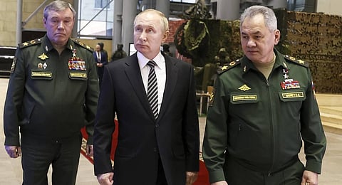 Russian President Vladimir Putin, center, escorted by Russian Defense Minister Sergei Shoigu, right, and General Staff Valery Gerasimov walk after attending an extended meeting. (Photo | AP)