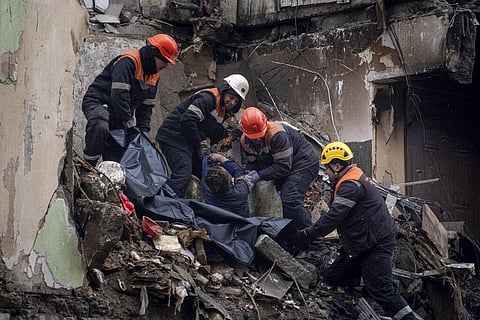 Rescue workers transfer the body of a man killed in a Russian missile strike on an apartment building, into a plastic bag in the southeastern city of Dnipro, Ukraine, Jan. 16, 2023. (Photo | AP)