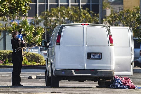 A forensic photographer takes pictures of a van's window and its contents in Torrance from which a body is retrieved | AP