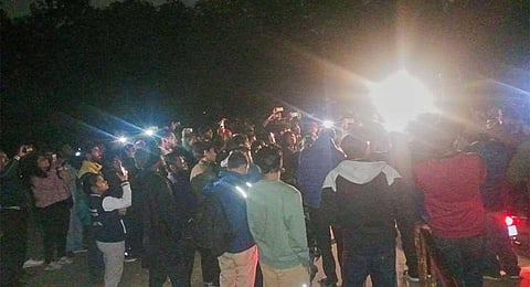Students stand outside the JNUSU Office alleging that the JNU administration has cut off electricity supply to prevent the screening of BBC documentary ‘India: The Modi Question’ in New Delhi, Tuesday