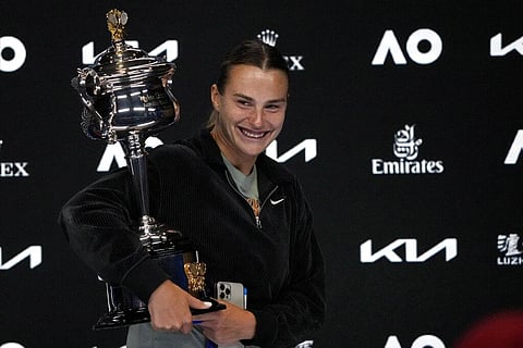 Aryna Sabalenka of Belarus carries the Daphne Akhurst Memorial Trophy as she leaves her press conference after defeating Elena Rybakina of Kazakhstan. (Photo | AP)