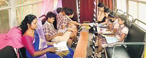 Students and teachers of Pragathi English Medium School reading inside the bus that has been converted into a library | Shaji vettippuram
