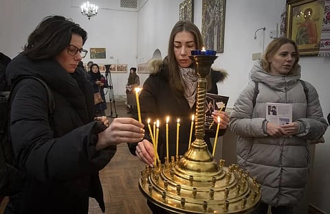 People light candles to commemorate British volunteers Chris Parry & Andrew Bagshaw, during commemorating service in a refectory near St. Sophia Cathedral in Kyiv, Ukraine, Jan. 29, 2023. (Photo | AP)