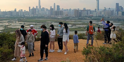 People visit the border of Hong Kong, with the skyline of China's Shenzhen in the background, in Hong Kong. (Photo | AP)