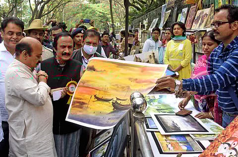 Chief Minister Basavaraj Bommai purchases a painting during Chitra Santhe in Bengaluru on Sunday. (Photo | Shashidhar Byrappa, EPS)