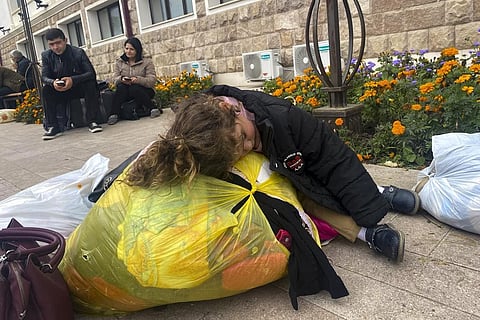 FILE - A child sleeps on a bag with clothes and other belongings as people hoping to leave Nagorno-Karabakh gather in the city of Stepanakert on Monday, Sept. 25, 2023. (Photo | AP)