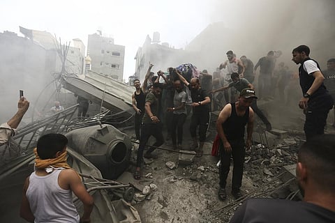 Palestinians remove a dead body from the rubble of a building after an Israeli airstrike Jebaliya refugee camp, Gaza Strip, Monday, Oct. 9, 2023. (Photo | AP)