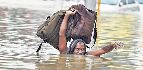 File photo of a man wading through neck-deep flood waters in Kotturpuram during heavy rains in Chennai | File pic