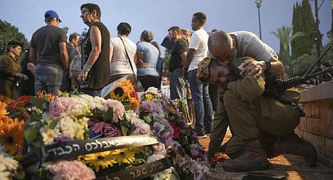 Friends and relatives of Ilai Bar Sade mourn next to his grave during his funeral at the military cemetery in Tel Aviv, Israel | AP