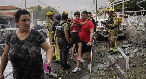 Israelis evacuate a site struck by a rocket fired from the Gaza Strip, in Ashkelon, southern Israel. (Photo | AP)