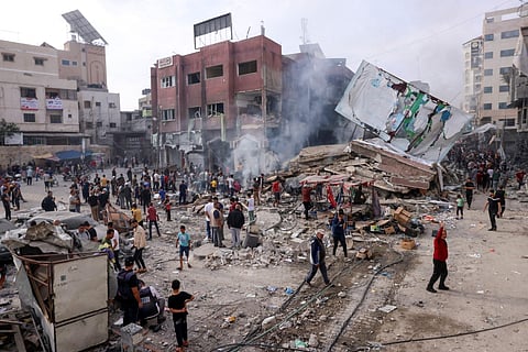 Palestinians inspect the rubble of a collapsed building in the heavily bombarded city centre of Khan Yunis in the Gaza Strip following overnight Israeli shelling, Oct. 10, 2023. (Photo | AFP)