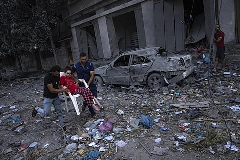 Palestinians walk amid the rubble following Israeli airstrikes that razes swathes of a neighbourhood in Gaza City, Oct 10, 2023. (Photo | AP)