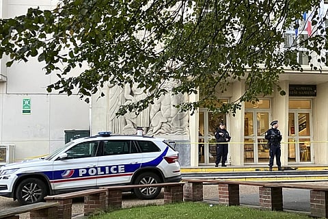 Police officers stand guard outside the high school where a man stabbed a teacher. (Photo | AP)
