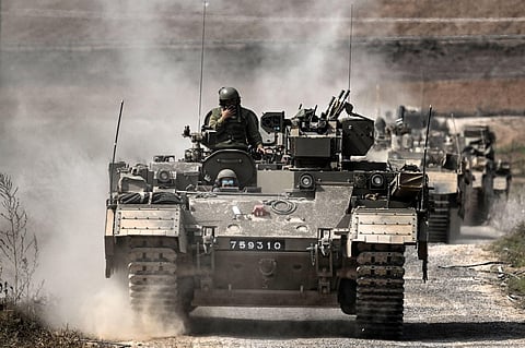 A column of Israeli army military armoured vehicles moves near the Gaza border