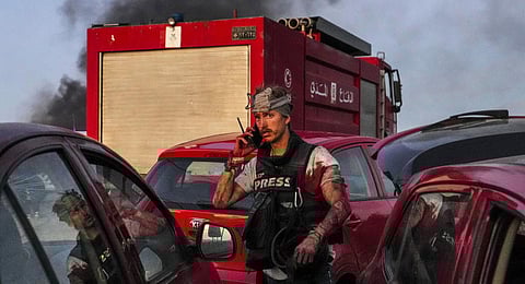 AFP cameraman Dylan Collins speaking on his mobile phone after being injured by Israeli shelling at Alma al-Shaab border village with Israel in southern Lebanon. (Photo | AFP)