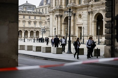 Staff leave the Louvre Museum as people are evacuated after a written threat, in Paris, Oct 14, 2023. (Photo | AP)